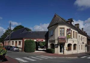 ein Gebäude an der Ecke einer Straße mit einem Hotel in der Unterkunft Hotel Restaurant Le Cygne in Conches-en-Ouche