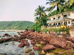 a house on the shore of a rocky beach at Shree Sai Beach Stay in Arambol