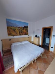 1 dormitorio con 1 cama con una pintura en la pared en Bed & breakfast Villa Maria en Cavalese