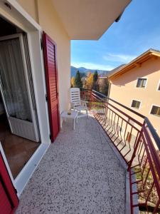 een balkon met een witte stoel in een gebouw bij Bed & breakfast Villa Maria in Cavalese