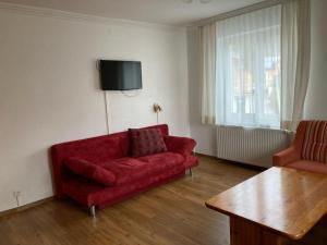 a living room with a red couch and a table at Appartement Ahornegger in Schladming