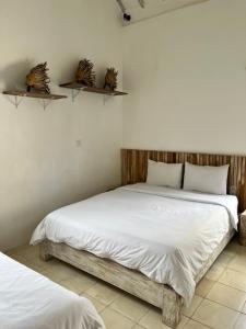 a bedroom with two beds and shelves on the wall at Villa Tom & Lucie Bingin Beach in Uluwatu