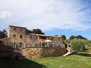 une grande maison en pierre avec un mur en pierre dans l'établissement Il Casalino, à Gualdo Tadino