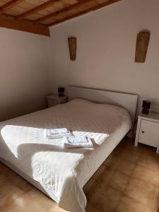 ein Schlafzimmer mit einem weißen Bett mit zwei Handtüchern darauf in der Unterkunft Typique maison de village in Saint-Quentin-la-Poterie