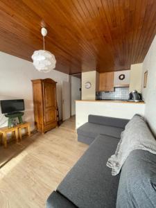 a living room with a couch and a kitchen at Le Chamois in Chamrousse