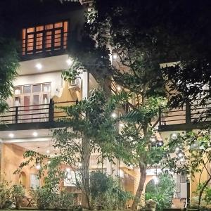 a building with trees in front of it at night at Onilwe Resort Weligama in Weligama