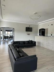 a living room with a black leather couch in a room at Kacoke Madit Hotel and Cultural Centre, Gulu in Gulu