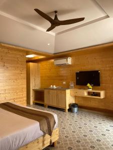 a bedroom with a bed and a flat screen tv at Grace Exotica Goa in Canaguinim