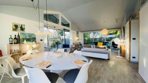 ein Esszimmer und ein Wohnzimmer mit einem weißen Tisch und Stühlen in der Unterkunft Jolie maison avec jardin, piscine et parking in Sainte-Marie-de-Ré