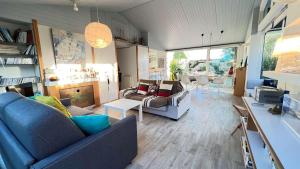 ein Wohnzimmer mit einem blauen Sofa und einem Tisch in der Unterkunft Jolie maison avec jardin, piscine et parking in Sainte-Marie-de-Ré