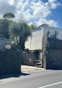 una casa con una pared de piedra junto a una calle en Villetta Silvio Ischia, en Isquia