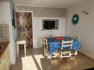 uma sala de jantar com uma mesa e cadeiras e uma televisão em TancaManna16 em Cannigione