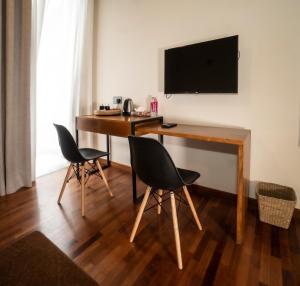 um quarto com uma secretária com 2 cadeiras e uma televisão em Hotel Bulwark em Nuwara Eliya