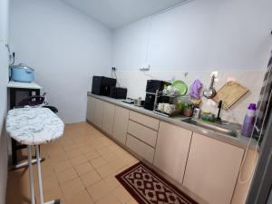 a kitchen with a counter and a sink and a stool at Thetamu Homestay مسلم Pesona in Jalan Baharu