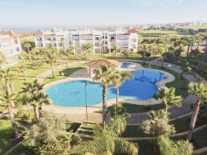 - une vue aérienne sur un complexe avec une piscine et des palmiers dans l'établissement Marina golf studio, à Assilah