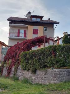 una casa con flores rojas creciendo en una pared en Bed & breakfast Villa Maria en Cavalese