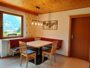 comedor con mesa, sillas y ventana en Apartments Pötscher en Matrei in Osttirol