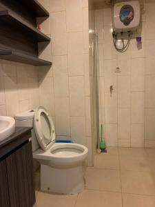 La salle de bains est pourvue de toilettes, d'une douche et d'un lavabo. dans l'établissement Vins Room at Mataram City Tower Sadewa, à Kejayan