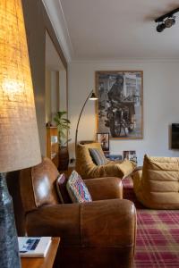 un soggiorno con 2 sedie in pelle e un divano di Aplace Antwerp - marvellous flats & hotel rooms ad Anversa