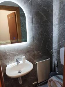 ein Bad mit einem Waschbecken und einem Spiegel in der Unterkunft Fotini studio in Thessaloniki