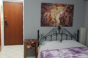 een slaapkamer met een bed en een schilderij aan de muur bij Fotini studio in Thessaloniki