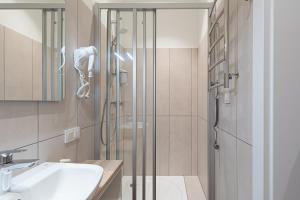 La salle de bains est pourvue d'une douche et d'un lavabo. dans l'établissement Dandelion Apartments Ģertrūdes, à Riga