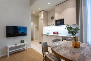 a kitchen and dining room with a table and chairs at Dandelion Apartments Ģertrūdes in Rīga