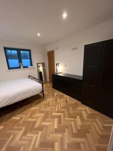 een slaapkamer met een bed en een houten vloer bij The Orchard - Ground Floor Flat in Bristol