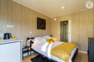 a bedroom with a large bed with a yellow blanket at La cigale et la fourmi savoisienne - gîtes in Aix-les-Bains