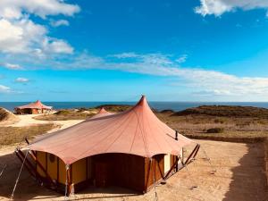 a tent in the desert with the ocean in the background at Quinta Aurora in Burgau