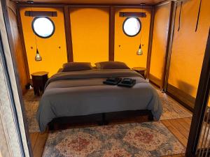 1 dormitorio con 1 cama grande en una habitación con 2 ventanas en Quinta Aurora, en Burgau