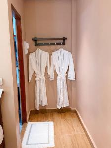 two white robes hanging on a rack in a room at Champathong Garden Resort in Vang Vieng