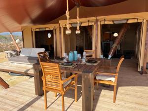 einen Holztisch und Stühle auf einer Terrasse in der Unterkunft Quinta Aurora in Burgau