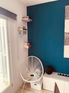 - un ventilateur blanc dans une chambre dotée d'un mur bleu dans l'établissement Penthouse Sitges, à Sitges