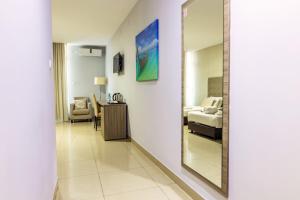 a hallway with a mirror and a bedroom at Hotel Fénix in Nampula