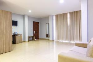 a living room with a couch and a tv at Hotel Fénix in Nampula