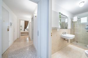 une salle de bain blanche avec un lavabo et une douche dans l'établissement [3 minutes from Piazza Maggiore] Historical flat, à Bologne
