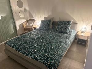 Un dormitorio con una cama con sábanas y almohadas azules y blancas en Appartement cosy - Port Marianne - Garage sous sol, en Montpellier