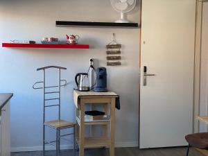 een kamer met een deur en een tafel met een waterkoker bij De Meerval in Katwijk aan Zee