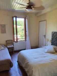 a bedroom with two beds and a window at La Maison du Bonheur in Anlhiac