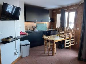 uma cozinha com uma mesa e cadeiras numa cozinha em Plagne Soleil : Pistes et vue em La Plagne Tarentaise