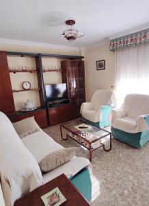 sala de estar con 2 sofás y TV en Piso Vélez Málaga en Vélez-Málaga