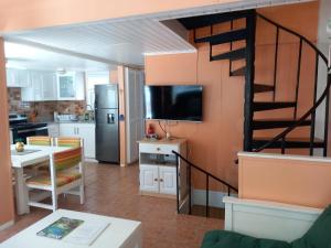 a kitchen and dining room with a spiral staircase in a house at Sealofts On The Beach in Frigate Bay