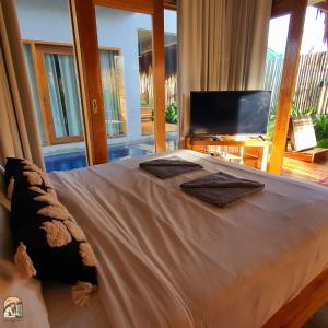 a bedroom with a large bed with a large window at Luna Tres Homestay Siargao in General Luna