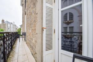 an open door on a building with a balcony at Appt 5 pers au coeur de Dinard classé 2 étoiles in Dinard