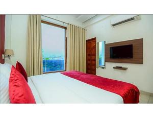 een slaapkamer met een bed en een groot raam bij Awadh Inn ,Lucknow in Lucknow