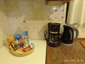 a counter top with a coffee maker and a basket of food at Επικούρεια Κατοικία in Gorgogýrion