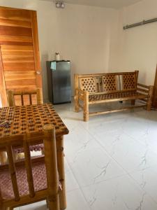 a kitchen with wooden tables and a refrigerator at Mikhaila Place is full in Iloilo City