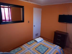 ein kleines Schlafzimmer mit einem Bett und einem Spiegel in der Unterkunft HOSTAL LA CASONA ALFREDO CAMPOS in Ovalle