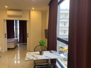 阿拉尼亚Rose 5的客厅里有一张桌子和一扇大窗户。